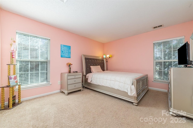 bedroom featuring light colored carpet and multiple windows