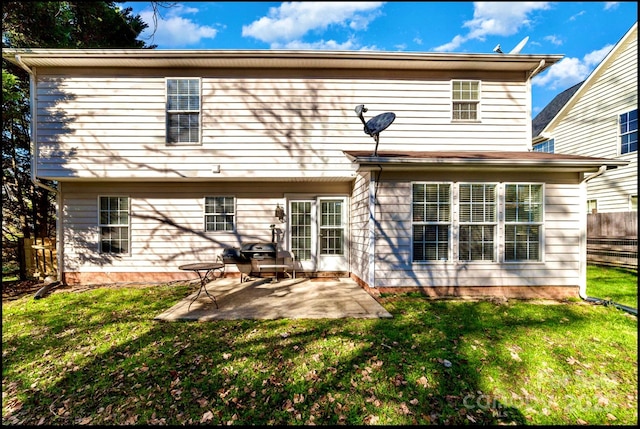 back of property with a yard and a patio area