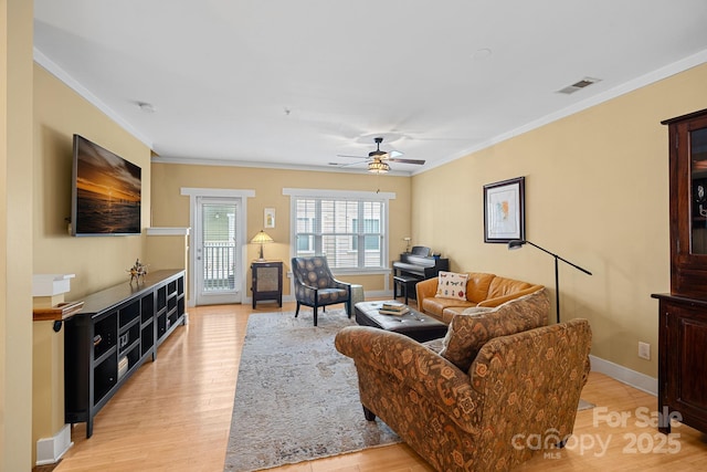 living room with ornamental molding, ceiling fan, and light hardwood / wood-style floors