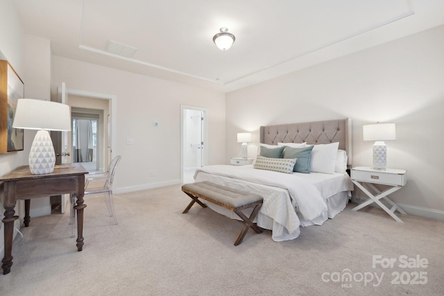 bedroom with a raised ceiling and light carpet