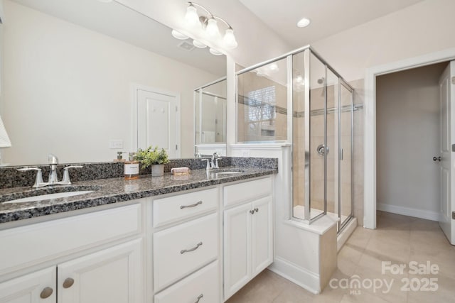 bathroom with vanity, a shower with shower door, and tile patterned flooring