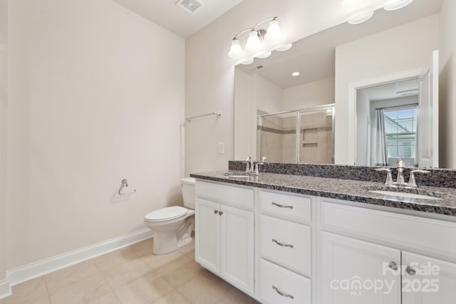 bathroom featuring tile patterned floors, vanity, toilet, and a shower with shower door