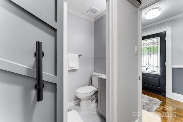 bathroom featuring vanity, toilet, and ornamental molding