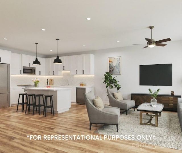 living room featuring sink, ceiling fan, and light hardwood / wood-style flooring