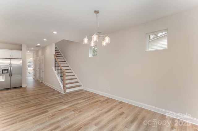 interior space with baseboards, stairway, light wood-type flooring, and a healthy amount of sunlight