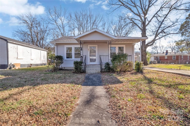 bungalow-style home with covered porch and a front yard