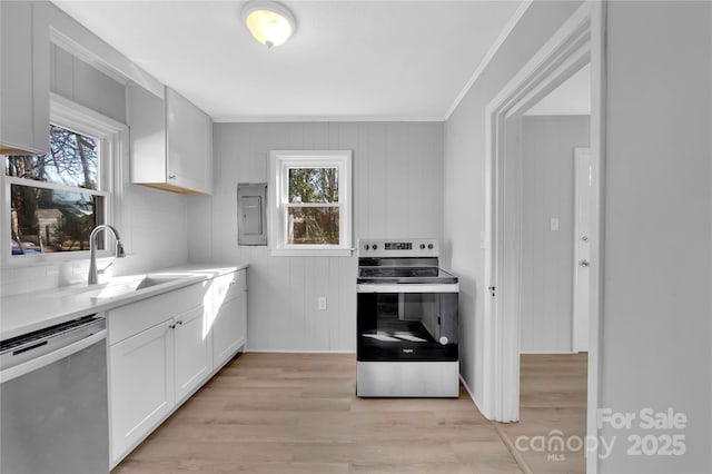 kitchen with appliances with stainless steel finishes, a healthy amount of sunlight, white cabinetry, and sink