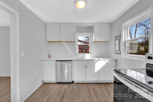 kitchen featuring stainless steel appliances, light hardwood / wood-style floors, white cabinetry, and sink