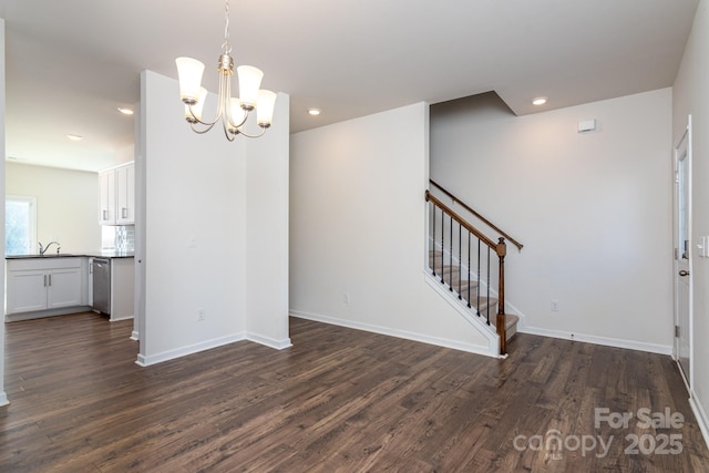 unfurnished dining area featuring sink, dark wood-type flooring, and a chandelier