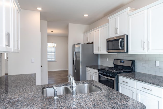 kitchen with dark stone counters, sink, decorative backsplash, white cabinetry, and stainless steel appliances