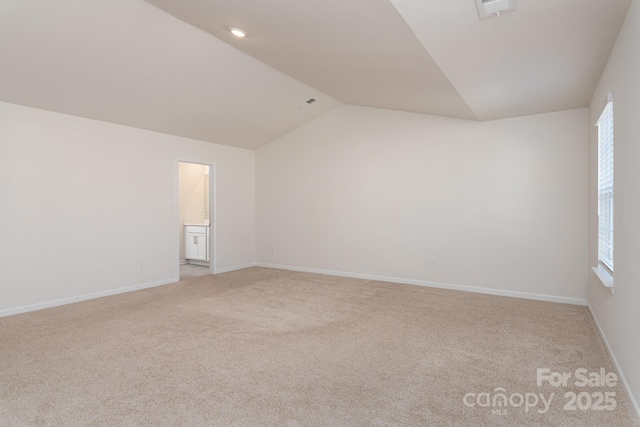 carpeted empty room featuring lofted ceiling and a wealth of natural light