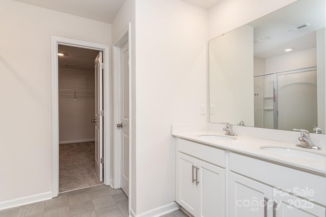 bathroom with a shower with door and vanity