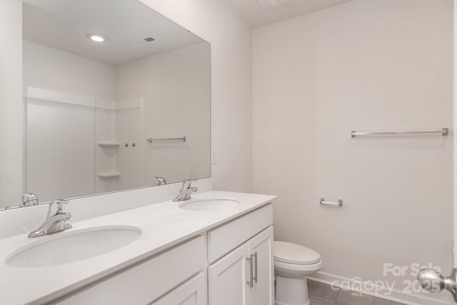 bathroom featuring tile patterned floors, vanity, and toilet