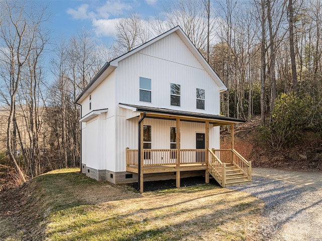 modern farmhouse style home with a front lawn and covered porch