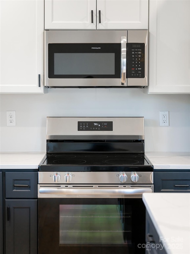 kitchen featuring stainless steel appliances and white cabinetry