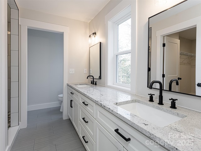 bathroom featuring a wealth of natural light, vanity, and toilet