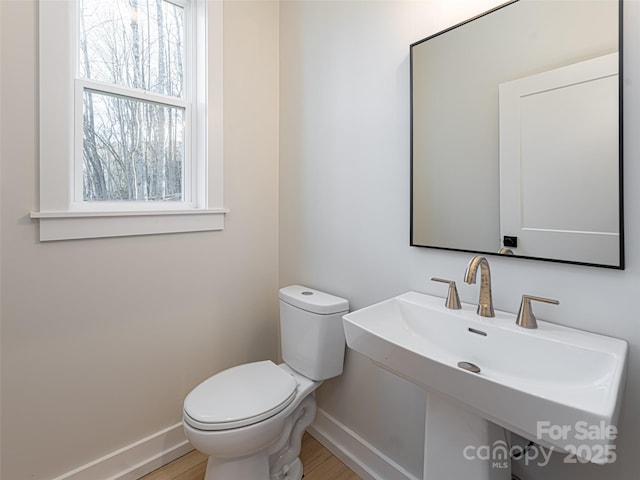 bathroom with wood-type flooring, toilet, and sink