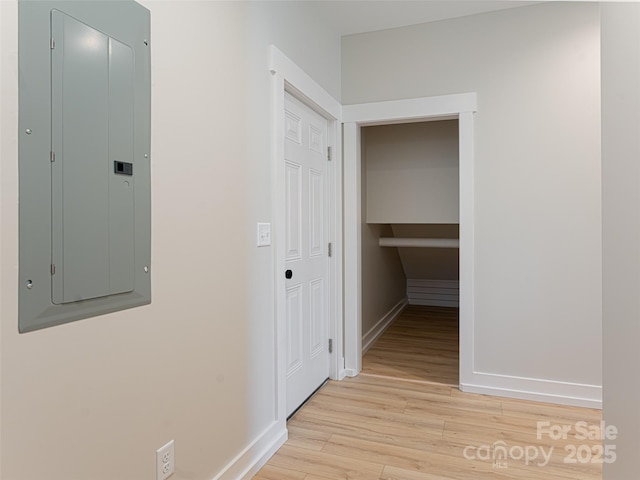 hallway featuring electric panel and light hardwood / wood-style flooring