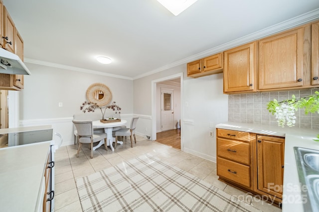 kitchen featuring light tile patterned floors, decorative backsplash, and ornamental molding