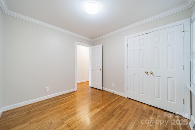 unfurnished bedroom featuring a closet, ornamental molding, and light hardwood / wood-style flooring