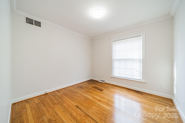 unfurnished room with ornamental molding and hardwood / wood-style flooring