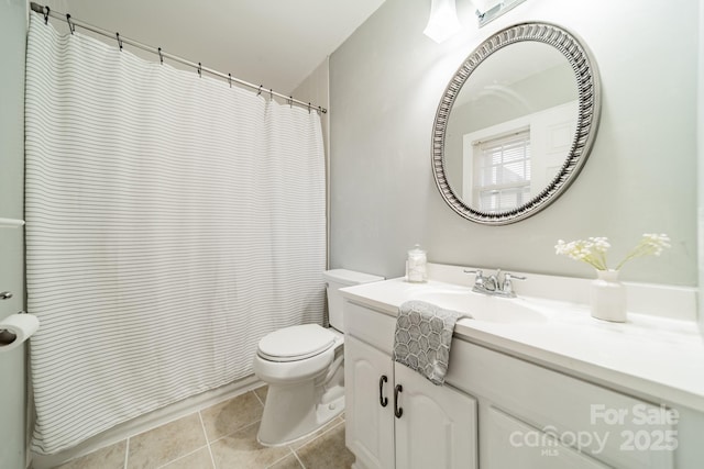 bathroom with toilet, vanity, and tile patterned flooring