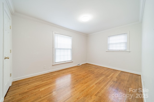 unfurnished room featuring ornamental molding and light hardwood / wood-style flooring