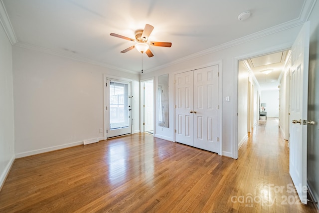 interior space with ceiling fan, crown molding, and light hardwood / wood-style flooring