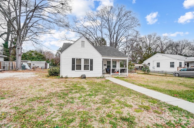 bungalow-style home featuring covered porch and a front lawn