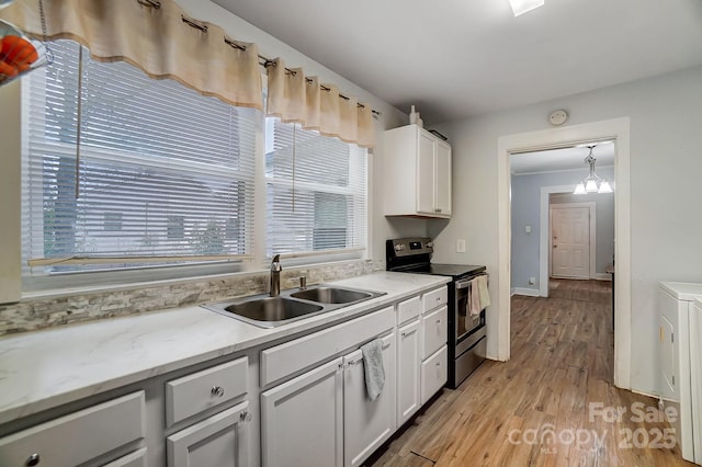 kitchen with white cabinets, stainless steel electric range, pendant lighting, and sink