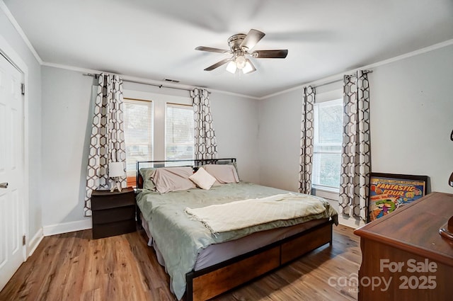 bedroom with hardwood / wood-style floors, ceiling fan, and crown molding