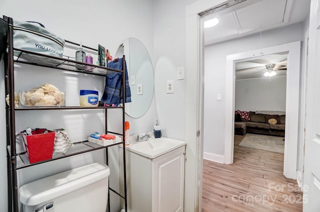 bathroom featuring ceiling fan, toilet, vanity, and hardwood / wood-style flooring