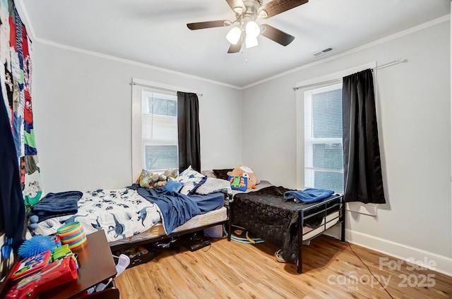 bedroom featuring hardwood / wood-style flooring, ceiling fan, and ornamental molding