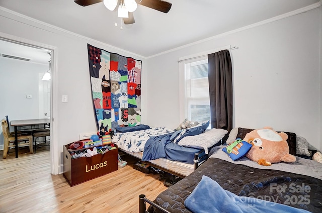 bedroom with hardwood / wood-style floors, ceiling fan, and ornamental molding