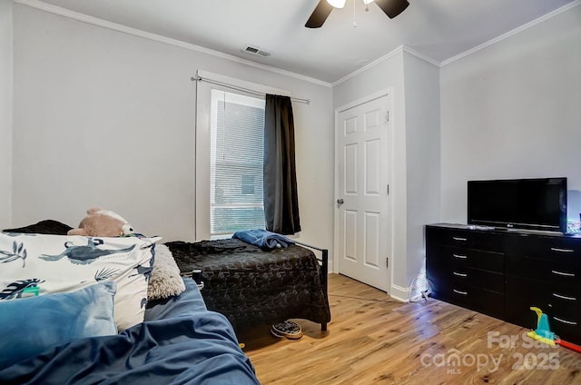 bedroom featuring light hardwood / wood-style floors, ceiling fan, and ornamental molding