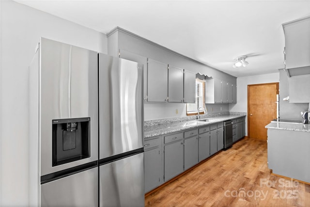 kitchen featuring gray cabinetry, light wood-type flooring, sink, and appliances with stainless steel finishes