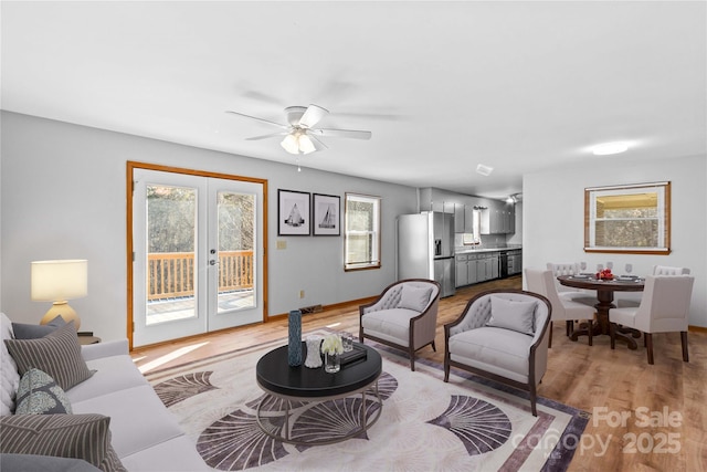 living room with french doors, light hardwood / wood-style floors, and ceiling fan