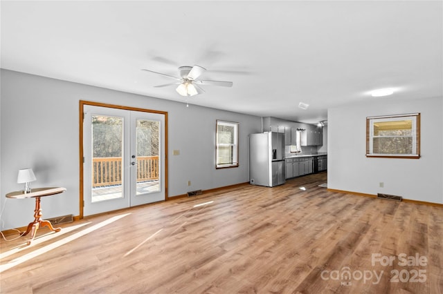 unfurnished living room with ceiling fan, light hardwood / wood-style floors, and french doors