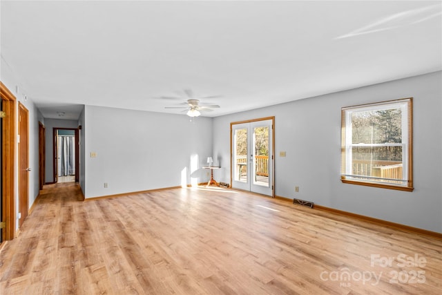 spare room featuring light wood-type flooring, plenty of natural light, and ceiling fan