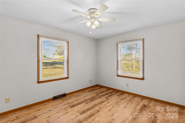 spare room with a wealth of natural light, light hardwood / wood-style flooring, and ceiling fan