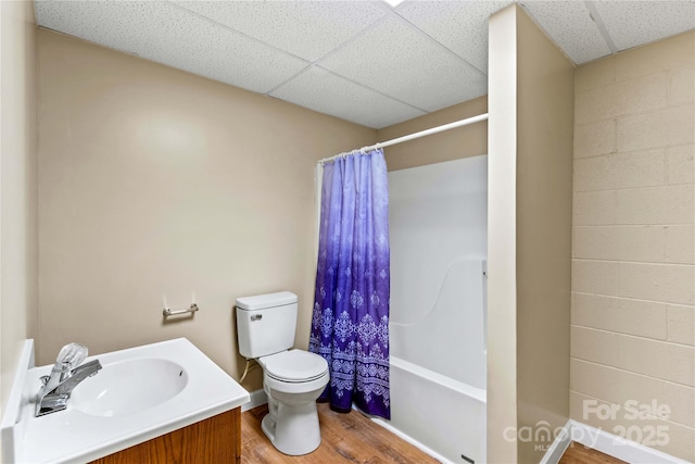 full bathroom with a paneled ceiling, vanity, toilet, shower / tub combo with curtain, and wood-type flooring