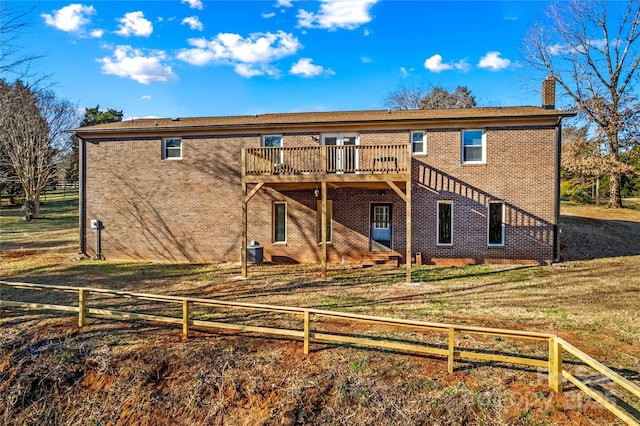 back of house featuring a yard, central AC unit, and a wooden deck