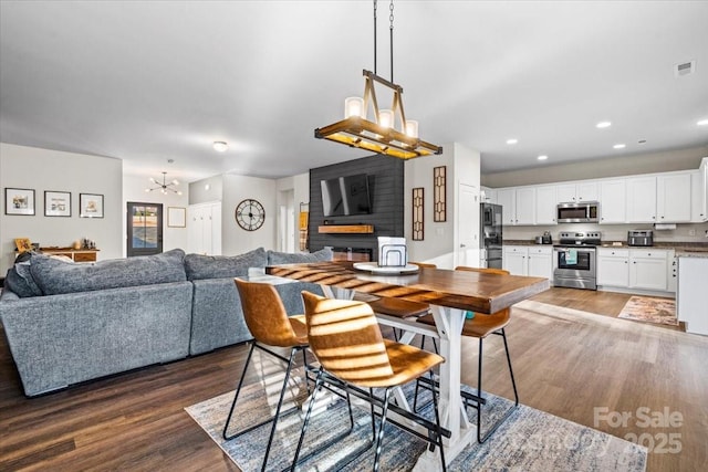 dining area with dark hardwood / wood-style floors and a notable chandelier