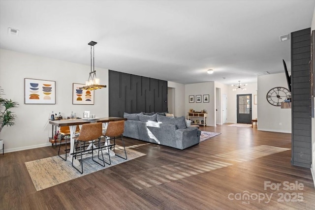 living room with dark wood-type flooring and a chandelier