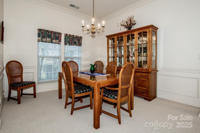 dining room featuring light carpet, a notable chandelier, and ornamental molding