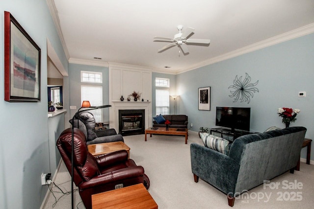 carpeted living room with ornamental molding and ceiling fan