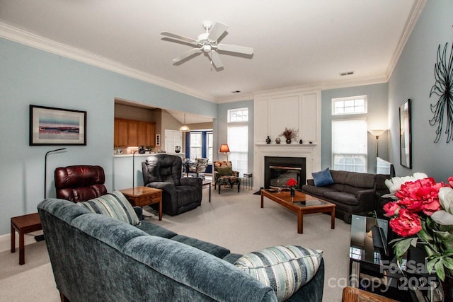 carpeted living room with ceiling fan and ornamental molding