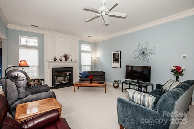 carpeted living room with crown molding, plenty of natural light, and ceiling fan