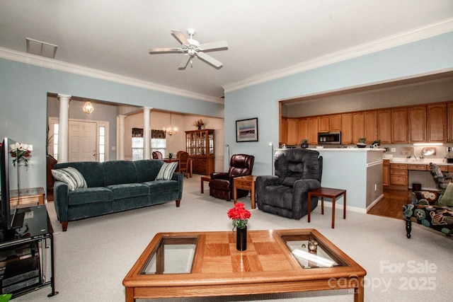 carpeted living room with ornamental molding, decorative columns, and ceiling fan