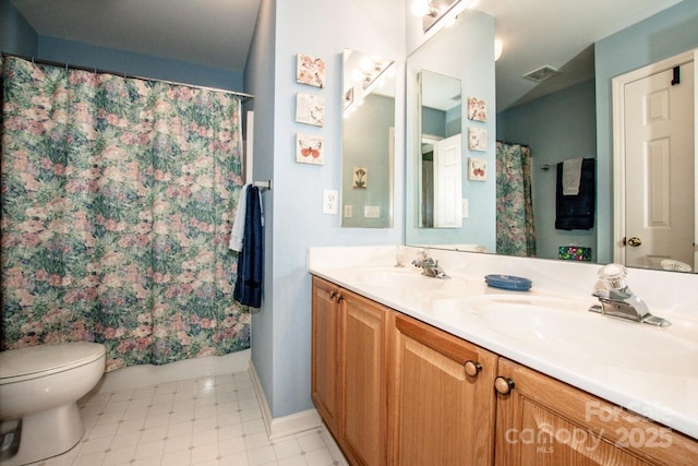 bathroom featuring vanity, walk in shower, and toilet